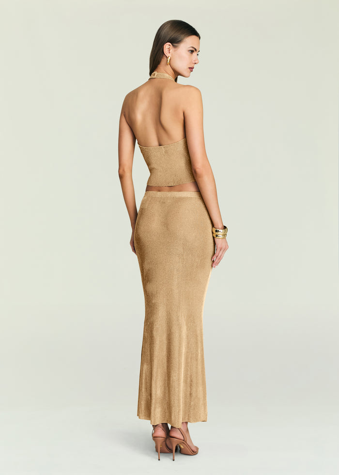 Back view of Minnie Metallic Knit Halter Top paired with a matching metallic skirt on a model.