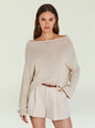 Beige knit Serafina Sweater worn off the shoulder with cream shorts, brown belt, gold hoops and a delicate necklace. thumbnail image 1 of 5