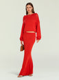 Full length shot of a model wearing a red cropped knit sweater and matching red skirt, holding a brown handbag thumbnail image 3 of 6
