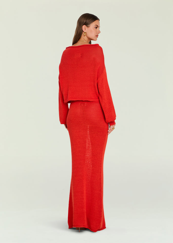 Back view of a model in a red knit cropped sweater with a matching red knit skirt
