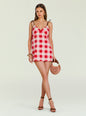 Model in a red and pink gingham mini dress with brown tie straps, gold jewelry, and a round woven bag. thumbnail image 1 of 5