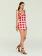 Model in a pink and red gingham mini dress with brown tie straps and strappy brown sandals. thumbnail image 3 of 5