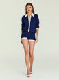 Front view of a model wearing a navy Silas Knit Romper with white collar and cuffs against a pale backdrop. thumbnail image 3 of 6