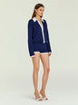Three-quarter side view of a model in a navy knit romper with white collar and cuffs thumbnail image 4 of 6
