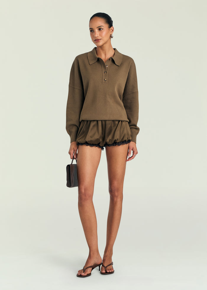 Woman wearing a brown outfit with a plain background