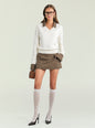 A model stands against a light gray studio background wearing a white long-sleeve knit sweater with brown trim, a brown mini skirt, white knee-high socks, black pointed heels, and holding a small brown handbag. thumbnail image 2 of 5