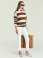 Model wearing Bryn Knit Sweater with wide brown and beige stripes over a white shirt, white trousers, and sunglasses. thumbnail image 4 of 6