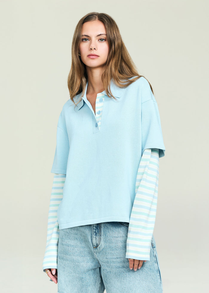 Emilee Top in light blue polo layered over a striped long sleeve worn by a model with denim jeans.