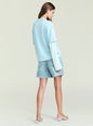 Back view of the Emilee Top in pale blue with a striped long sleeve underneath and denim shorts. thumbnail image 5 of 5