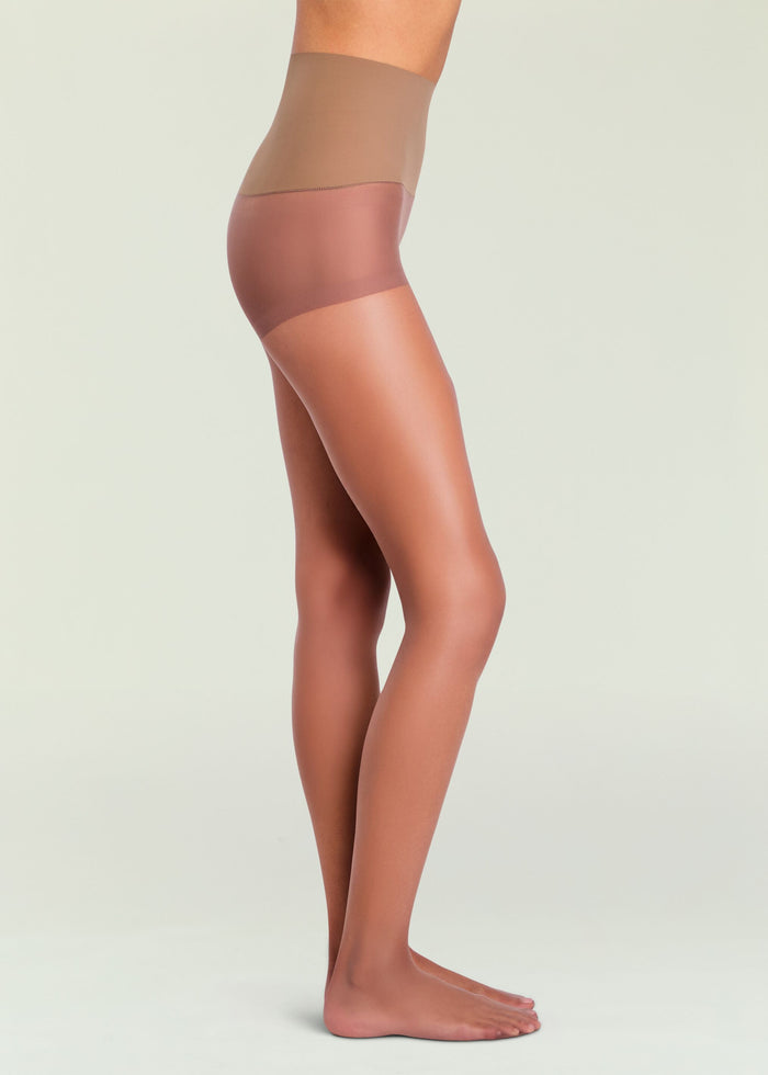 Profile view of a model wearing Highlighter Sheer Tights in beige with a high waist