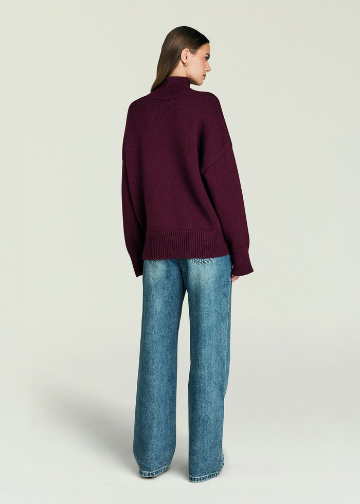Back view of Elsa Turtleneck Sweater in deep burgundy on a model, relaxed fit with ribbed hem.