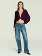 Model wearing burgundy Jerome Top with off the shoulder neckline and front twist knot, paired with denim jeans. thumbnail image 5 of 5