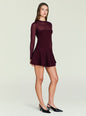 Model in a burgundy Joselyn Knit Mini Dress with a sheer bodice and a structured, flared skirt. thumbnail image 3 of 5
