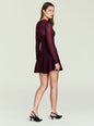 Side view of a model in a burgundy Joselyn knit mini dress with long sleeves and a flared skirt thumbnail image 4 of 5