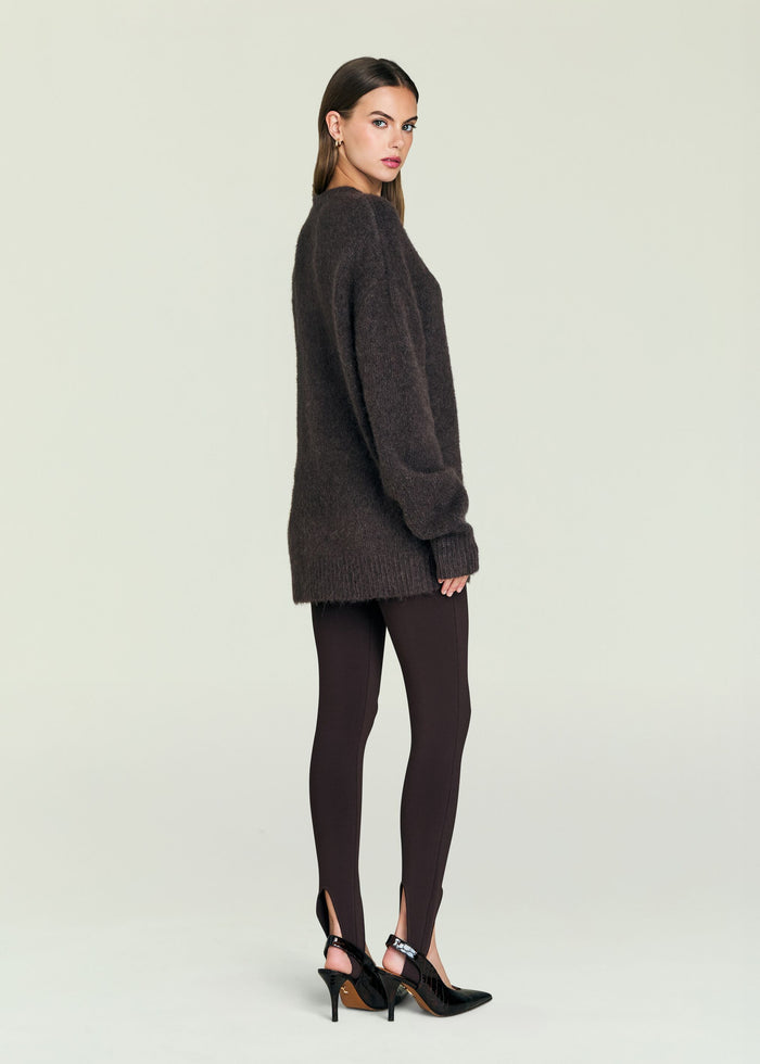 Full body shot of a model in the May Sweater paired with dark leggings and black heels.