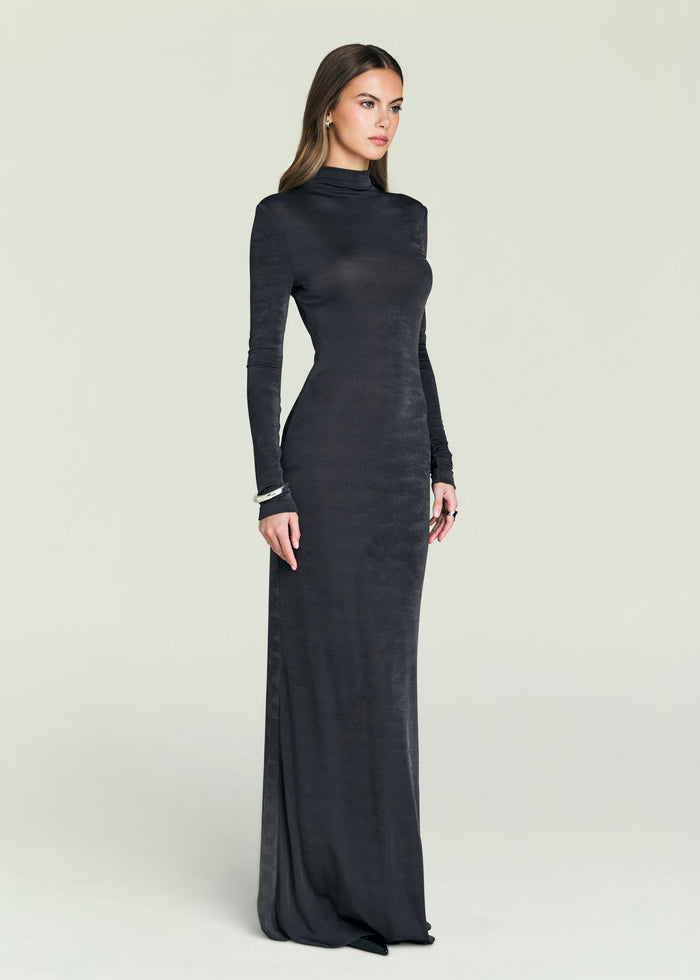 Model wearing a dark Kim Maxi Dress with a high neck and long sleeves against a pale backdrop