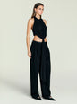 Profile view of Laura Top black halter with front knot paired with wide leg black pants thumbnail image 3 of 5