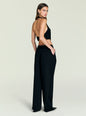 Side view of a woman in a black halter neck top with an open back and keyhole detail at the nape. thumbnail image 4 of 5