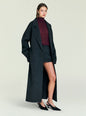 Model wearing a charcoal Lyli Wool Coat over a burgundy top and matching skirt photographed from a side angle thumbnail image 3 of 5
