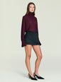 Full-length view of a model in a burgundy blouse with a dark charcoal Usha Wool Skirt and black heels. thumbnail image 4 of 5