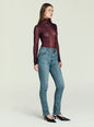 Side profile of a model wearing Celia high rise skinny jeans with a burgundy sheer turtleneck thumbnail image 4 of 5