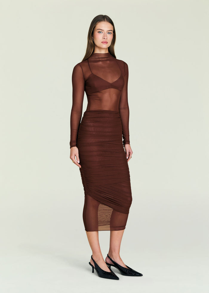 Thessa Ruched Skirt shown with a sheer brown top on a model.