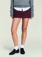 Burgundy Lillith Mini Skirt with a white shirt peeking from under a gray knit sweater. thumbnail image 1 of 4