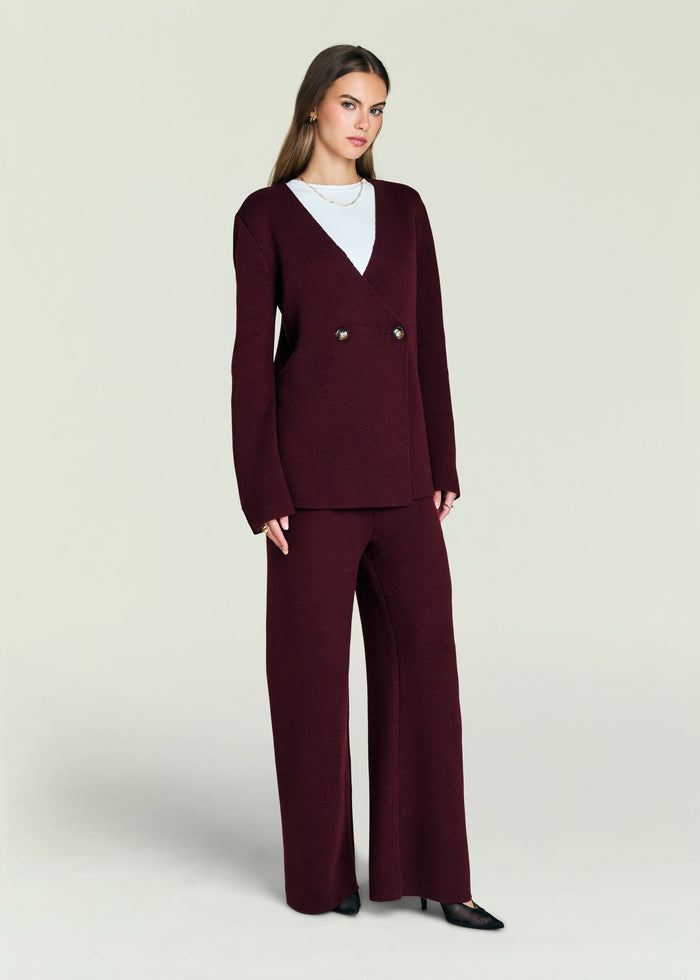 Model wearing burgundy Juna Knit Pant set with wrap blazer style top over a white tee
