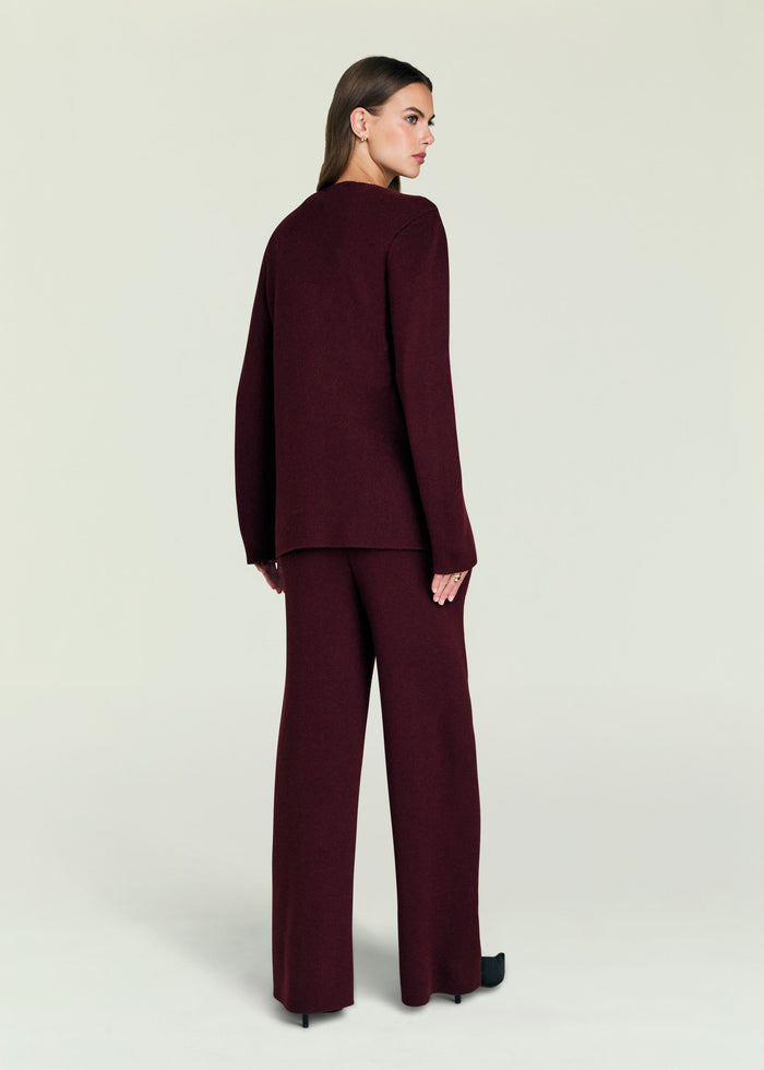 Back view of a model in a burgundy knit set featuring a loose sweater and wide-leg pants.