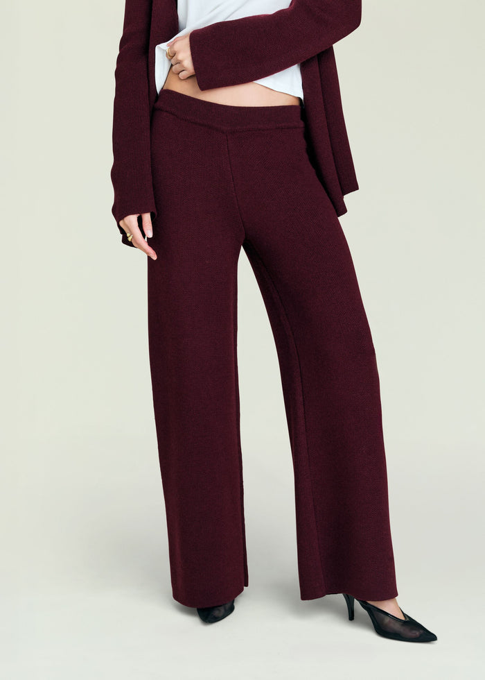 Close up of burgundy Juna Knit Pant waistband and knit texture with a white top peeking out