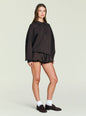 Vespen Sweater paired with satin shorts dark knit model wearing white socks and brown loafers against a pale backdrop thumbnail image 3 of 5