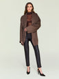 Model wearing Cyra Leather Legging with a brown oversized coat in a studio. thumbnail image 5 of 5