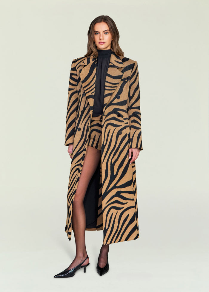 Long camel and black zebra print coat with double breasted front worn by a model