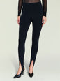 Front view of a model wearing black Kelsey Stirrup Leggings with seam panels and black pointed-toe heels. thumbnail image 1 of 5