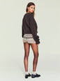 Side view of a model wearing a dark brown fuzzy knit top and beige patterned knit shorts. thumbnail image 4 of 5