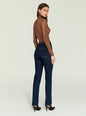 Side view of a woman wearing a brown ribbed turtleneck Piper Top with dark jeans. thumbnail image 4 of 5