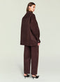 Three quarter view of a brown corduroy shacket over a brown turtleneck, belted at the waist with wide leg pants. thumbnail image 4 of 5
