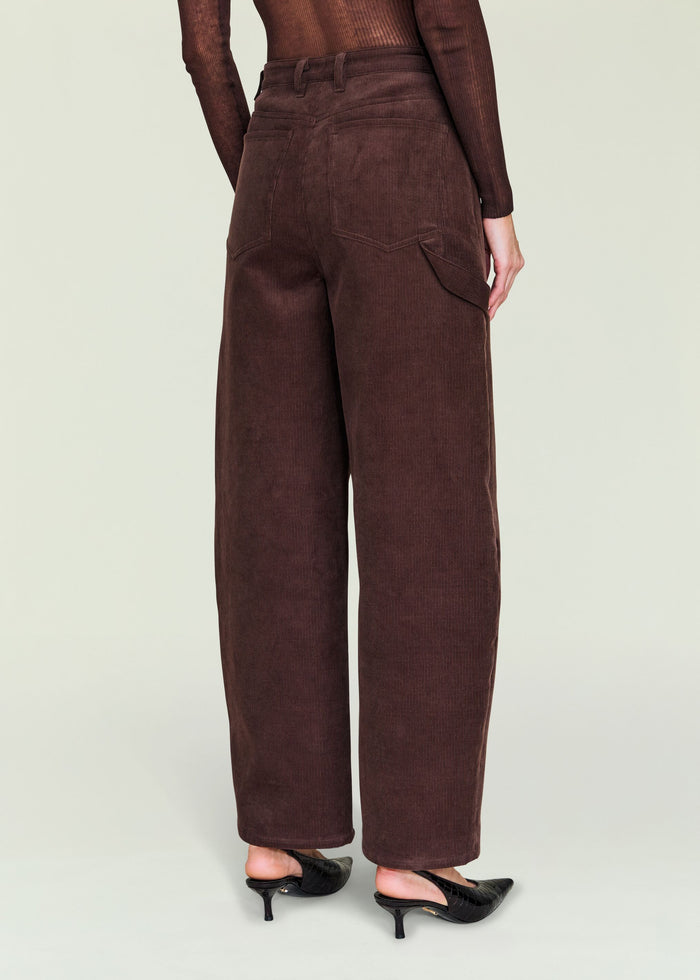 Back view of a model in burgundy corduroy pants with belt loops and large back pockets.