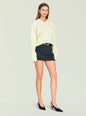 Model in cream Alejandra Sweater tucked into a dark mini skirt with a black belt and black heels. thumbnail image 3 of 5