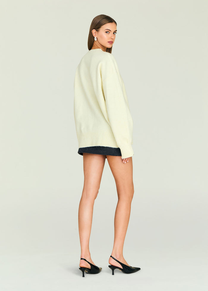 Back view of cream Alejandra Sweater on a model with a loose fit and ribbed hem.