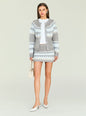 Model wearing a gray blue geometric knit cardigan with a matching mini skirt and holding a beige bag thumbnail image 5 of 5