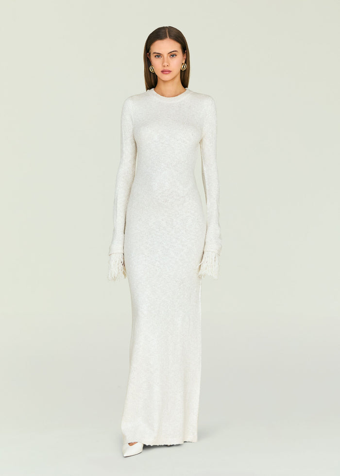 White Carina Maxi Dress with shimmering knit and fringed cuffs on the model.