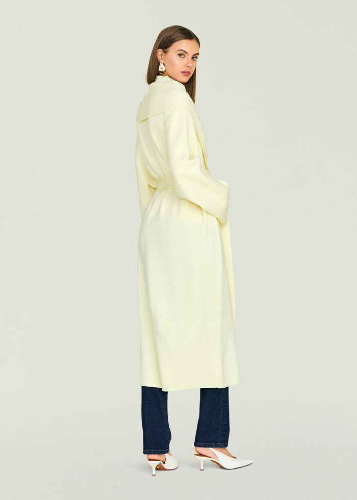 Crosby Sweater Duster pale yellow worn by model shown from the back with belt tied at the waist