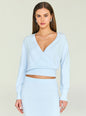 Model wearing a light blue wrap top from Jessalyn Reversible Knit Top with a deep V neckline and relaxed fit, accessorized with silver earrings and layered necklace thumbnail image 1 of 5