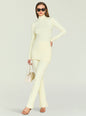 Model in a cream ribbed Velira Knit Pant set with turtleneck, carrying a beige handbag. thumbnail image 5 of 5