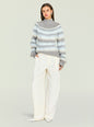Front view of a model in a grey blue geometric Tirza sweater paired with white pants thumbnail image 5 of 5