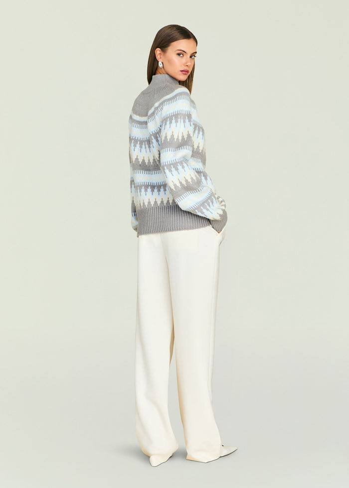 Side view of a model wearing a grey blue geometric knit Tirza sweater with a ribbed collar