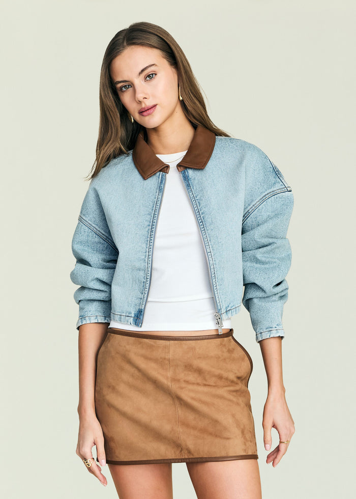 Model wearing a light wash Coop Denim Jacket with brown collar over a white top