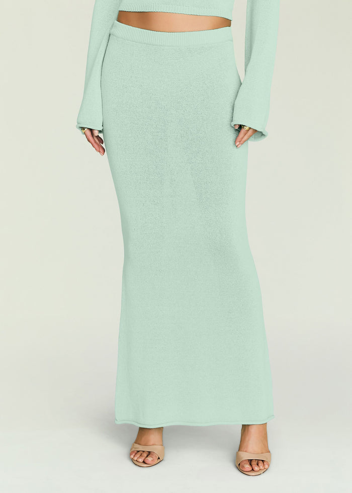 Close up of mint green knit maxi skirt showing a ribbed waistband and smooth textured fabric.