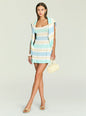 Three-quarter view of model wearing Azriel Knit Mini Dress with cardigan draped over shoulders, holding a pale yellow handbag and wearing yellow sandals. thumbnail image 5 of 5